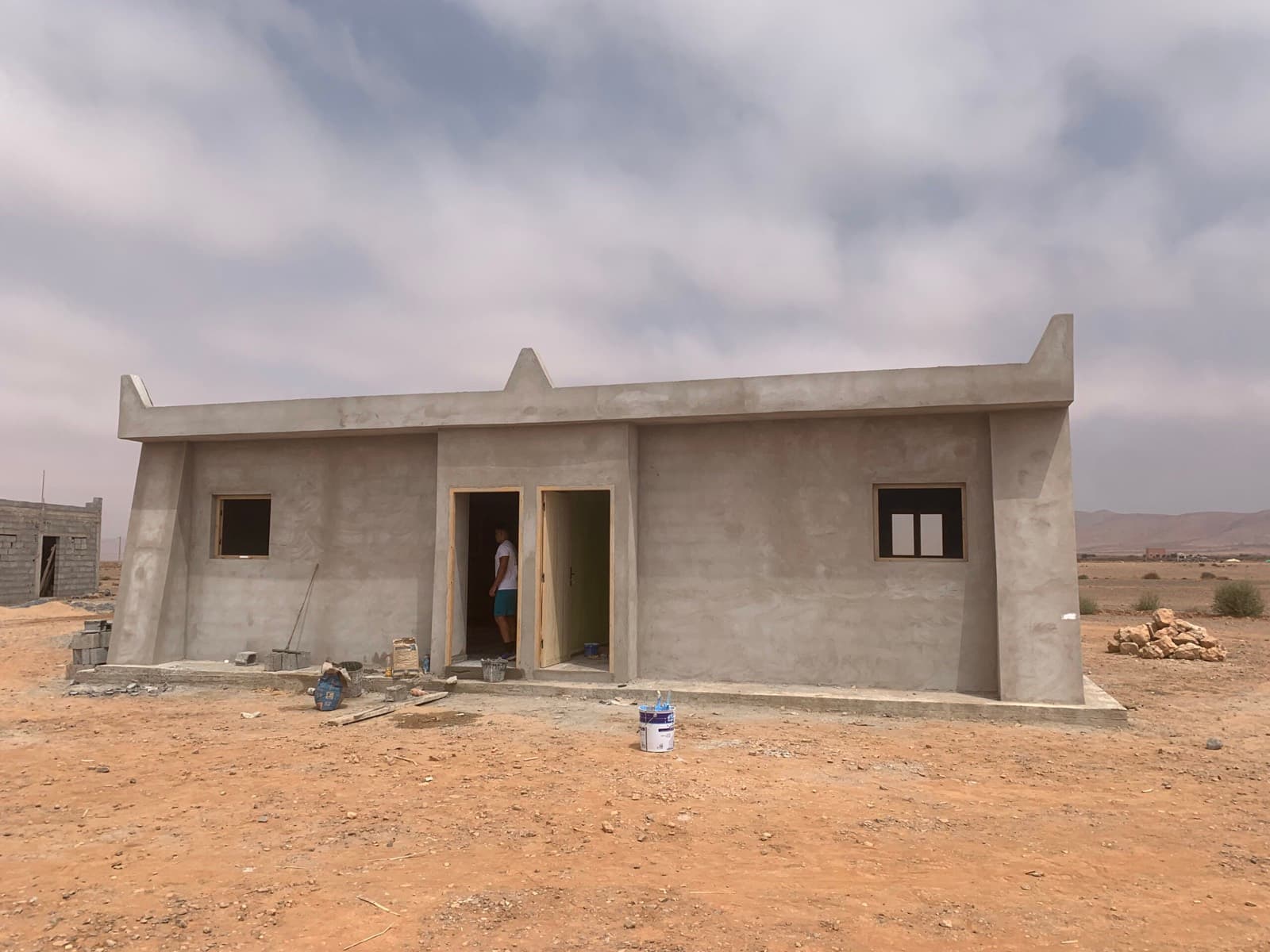L'école sortie de terre, encore en béton brut, avant les travaux de peinture.