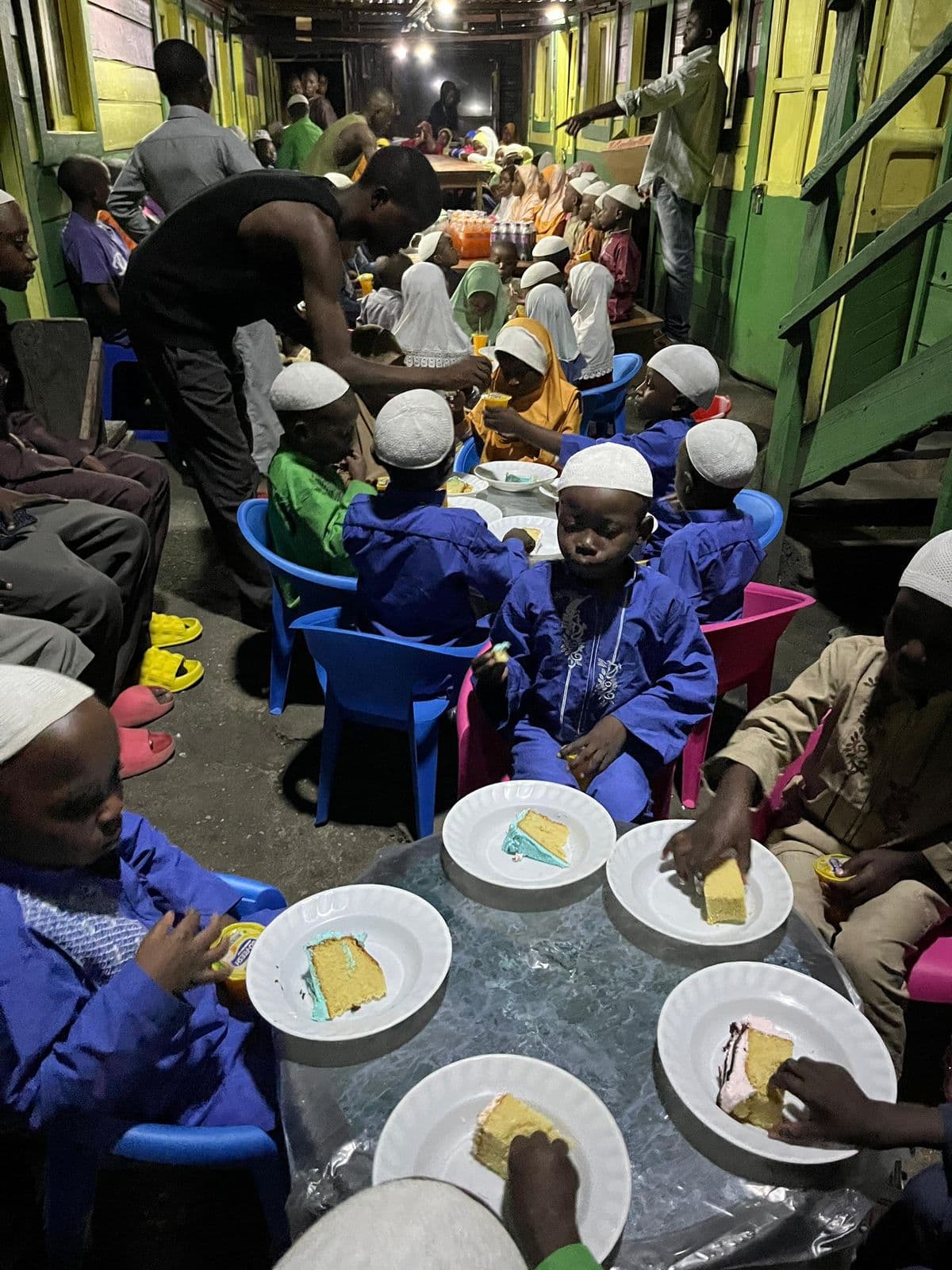Une longue salle où des dizaines d'enfants sont attablés pour un repas offert au Congo.