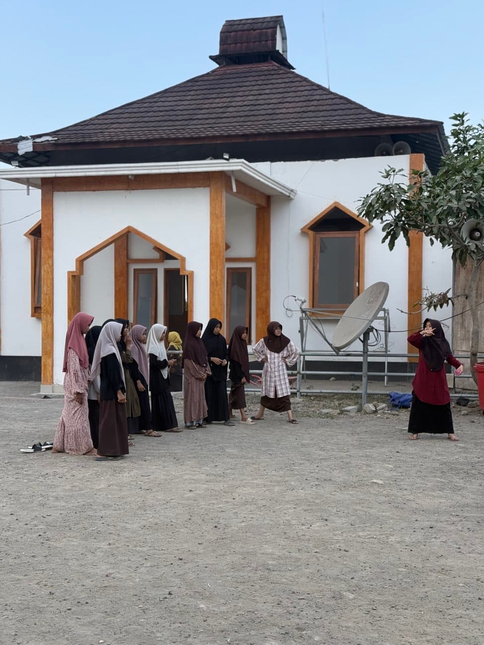 Le bâtiment blanc de l'orphelinat de Lombok, des femmes et des enfants rassemblés devant l'entrée.